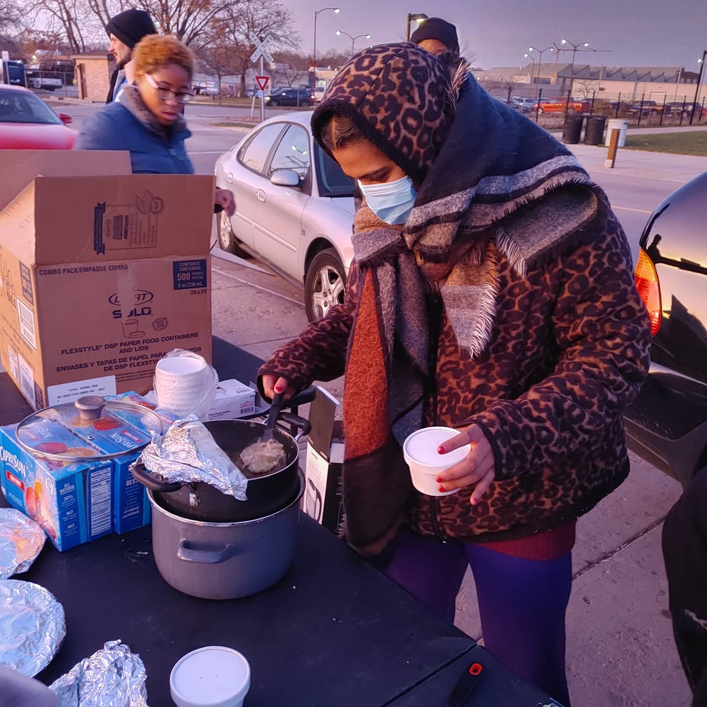 Anupama serving food to homeless at McPike park with Black Umbrella for Feed the Masses
